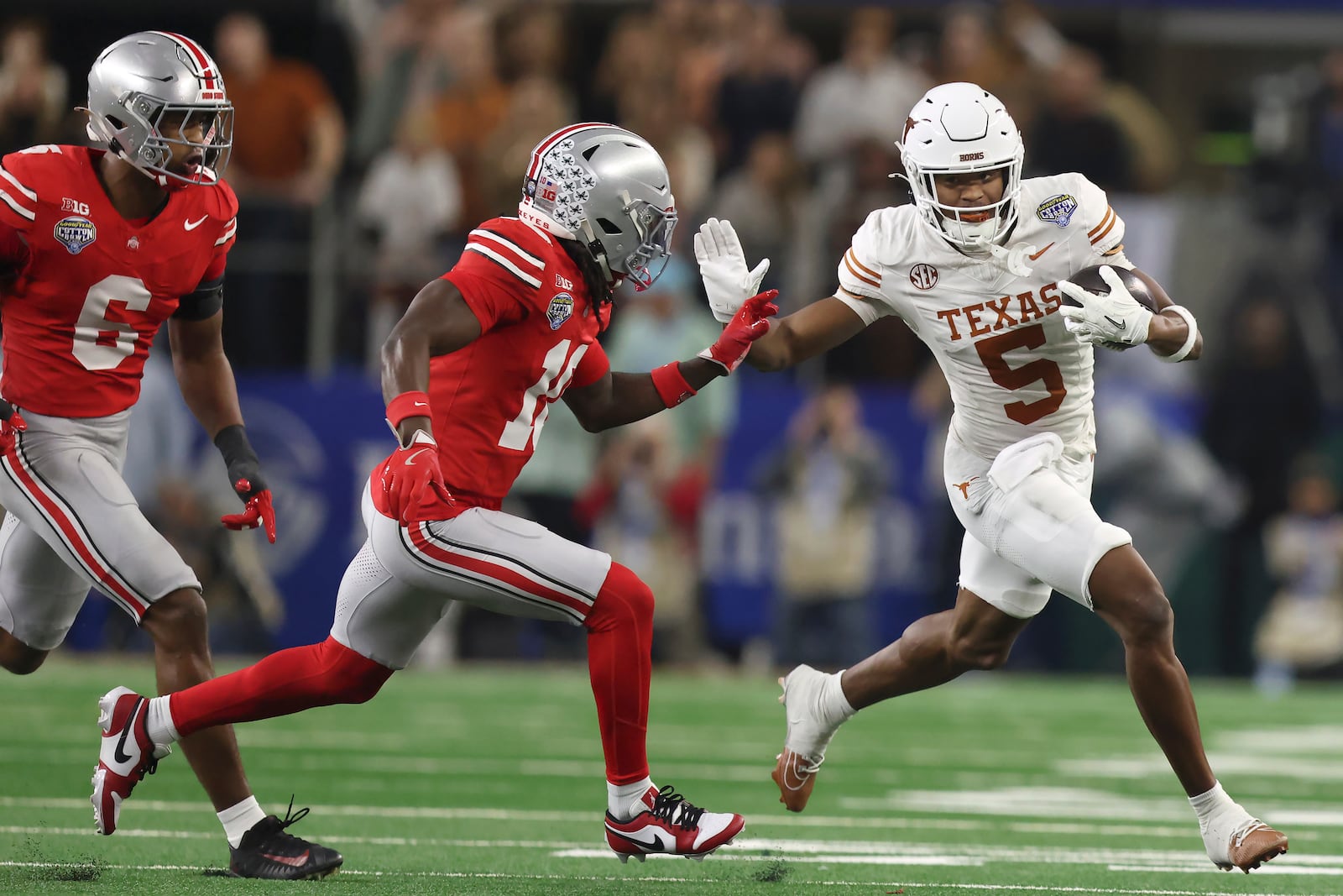 Texas wide receiver Ryan Wingo (5) runs against Ohio State safety Sonny Styles (6) and cornerback Denzel Burke during the first half of the Cotton Bowl College Football Playoff semifinal game, Friday, Jan. 10, 2025, in Arlington, Texas. (AP Photo/Gareth Patterson)