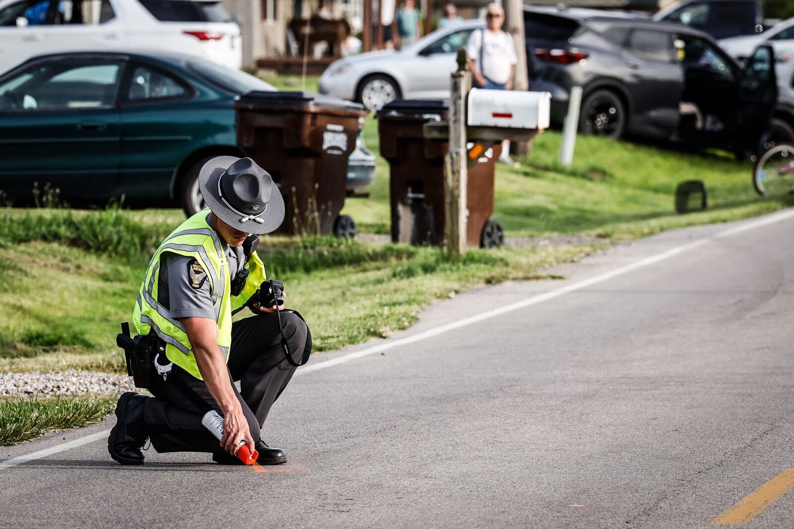 An Ohio State Highway Patrol trooper marks the roadway during an investigation Monday evening, June 20, 2022, after a man riding a motorbike was struck and killed on Franklin-Madison Road in Warren County. JIM NOELKER/STAFF