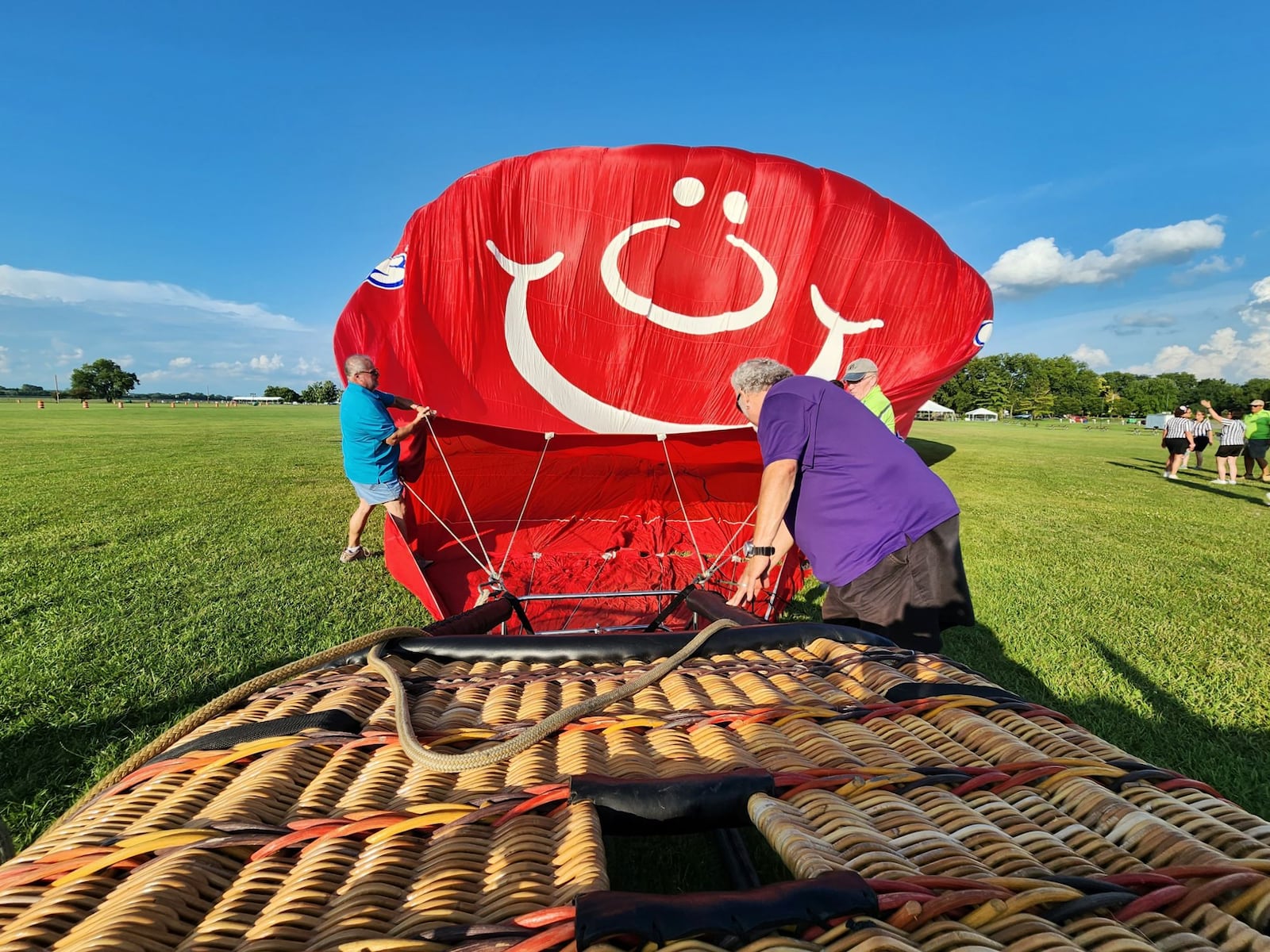 A crew with The Ohio Challenge hot air balloon festival helps Sean Askren inflate his Airheads balloon during a preview Thursday, July 20, 2023 at Smith Park in Middletown. NICK GRAHAM/STAFF