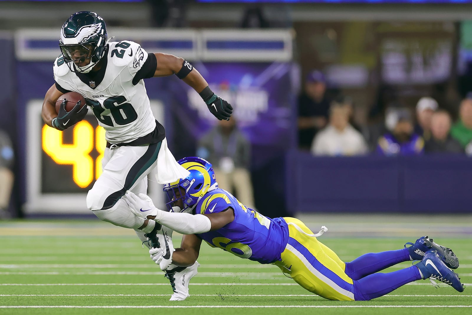 Philadelphia Eagles running back Saquon Barkley, left, runs against Los Angeles Rams safety Kamren Kinchens during the first half of an NFL football game in Inglewood, Calif., Sunday, Nov. 24, 2024. (AP Photo/Ryan Sun)