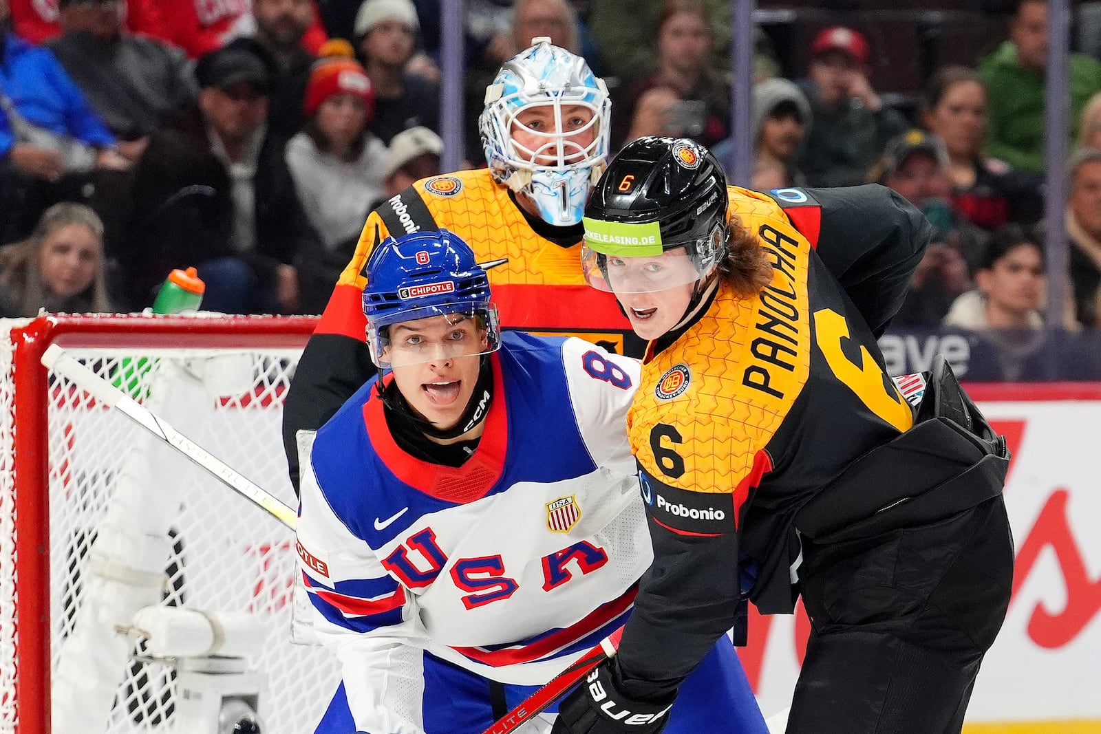 USA forward Brandon Svoboda (8), Germany defenceman Norwin Panocha (6) and teammate Nico Pertuch (1) look towards the puck during first period IIHF World Junior Hockey Championship preliminary round action in Ottawa on Thursday, Dec. 26, 2024. (Sean Kilpatrick/The Canadian Press via AP)