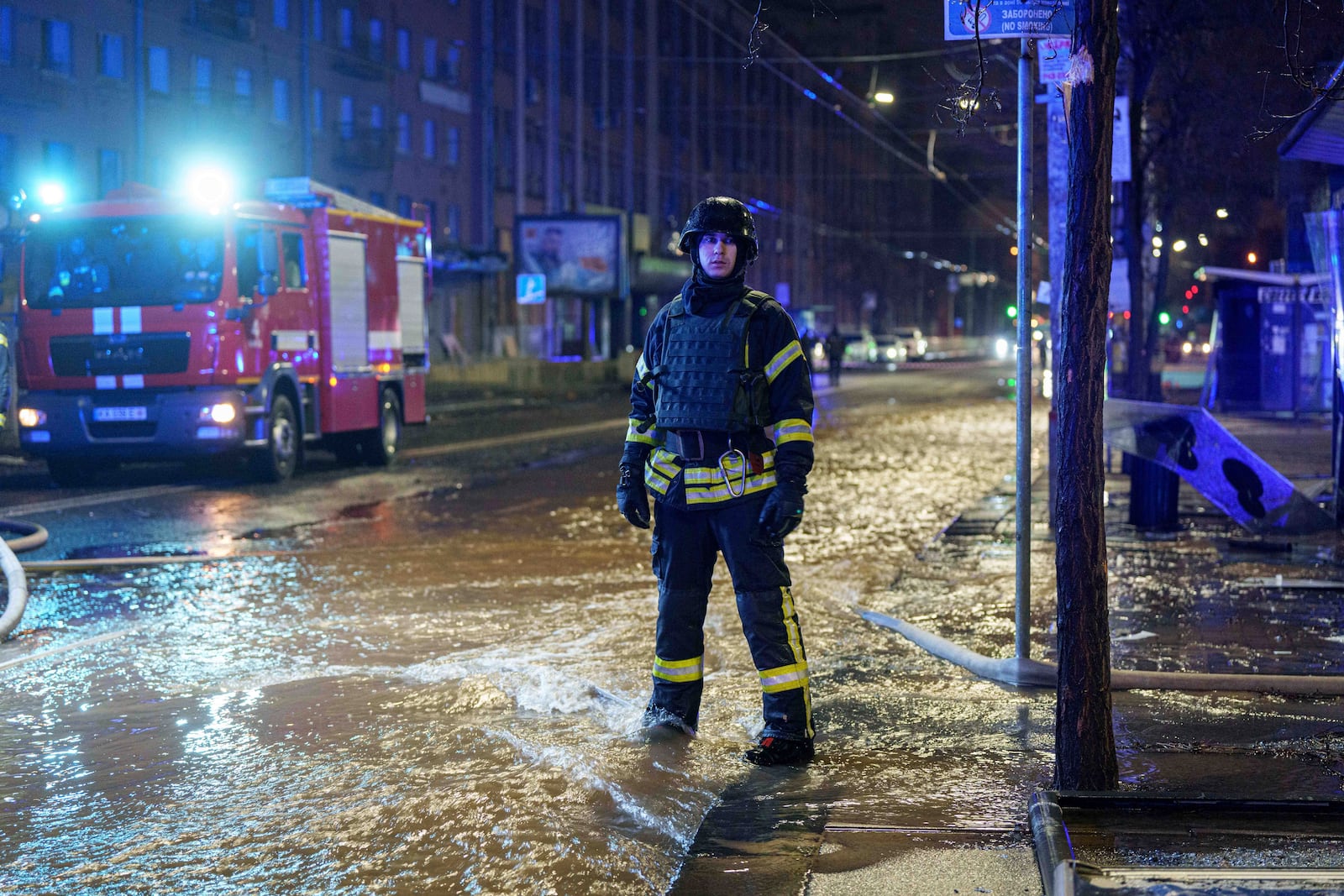 A rescue worker stands in a flooded street after a Russian missile strike on Kyiv, Ukraine, Saturday, Jan. 18, 2024. (AP Photo/Evgeniy Maloletka)