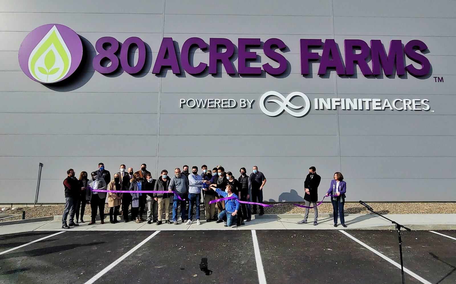 People involved with creating 80 Acres Farms' newest indoor growing farm snipped a long purple ribbon to ceremonially open the facility. NICK GRAHAM/STAFF