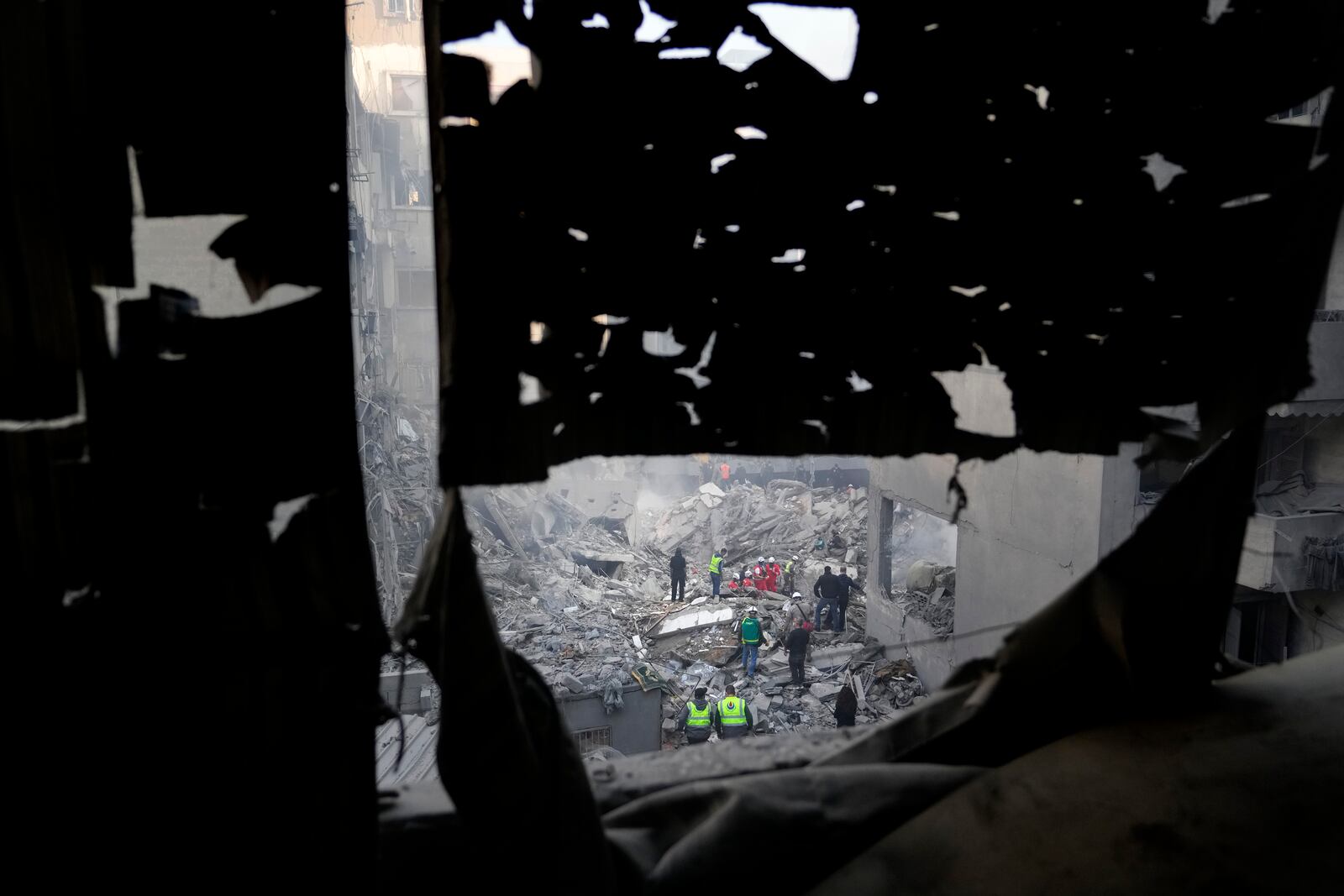 Rescue workers and people search for victims at the site of an Israeli airstrike that hit central Beirut, Lebanon, Saturday, Nov. 23, 2024. (AP Photo/Hassan Ammar)