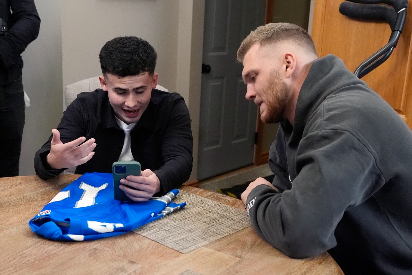 Detroit Lions' Aidan Hutchinson listens as Jacob Rinehart video calls with Lions' receiver Amon-Ra St. Brown, Thursday, Nov. 14, 2024, in Chesterfield Township, Mich. (AP Photo/Carlos Osorio)