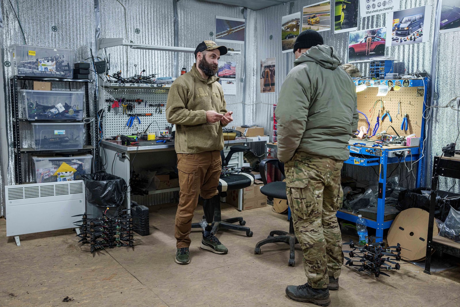 Pavlo Romanovskyi, chief of a Ukrainian drone laboratory who lost a leg in battle, talks to a fellow soldier in Ukraine's Kharkiv region on Feb. 12, 2025. (AP Photo/Evgeniy Maloletka)