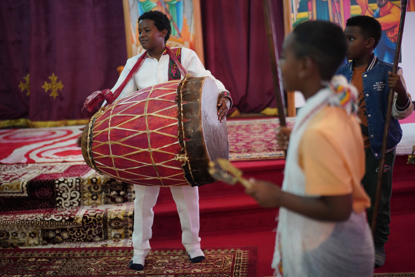 A young member of the Ethiopian Orthodox Tewahedo Church holds the kebero, a hand drum used in worship, on Sunday, Oct. 20, 2024, in Worthington, Minn. (AP Photo/Jessie Wardarski)