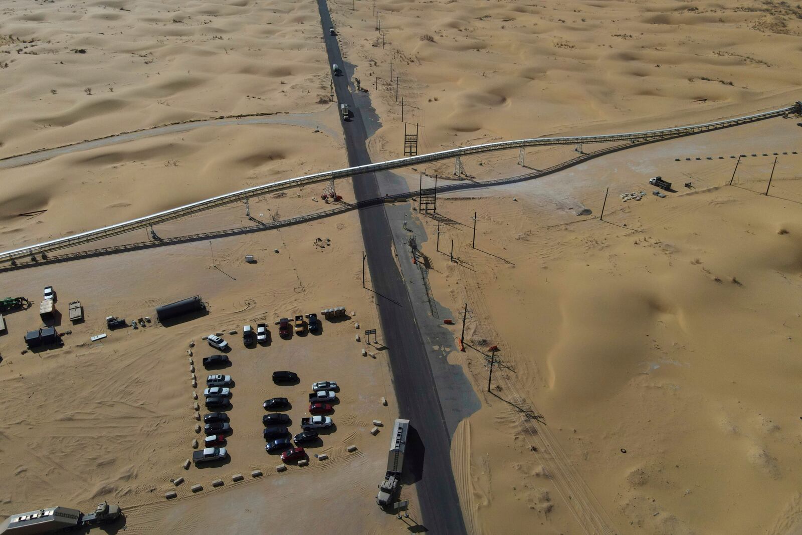 A 42-mile conveyor belt by Atlas Energy cuts through a sand dune as it carries sand needed for hydraulic fracturing Wednesday, Feb. 26, 2025, in Kermit, Texas. (AP Photo/Julio Cortez)