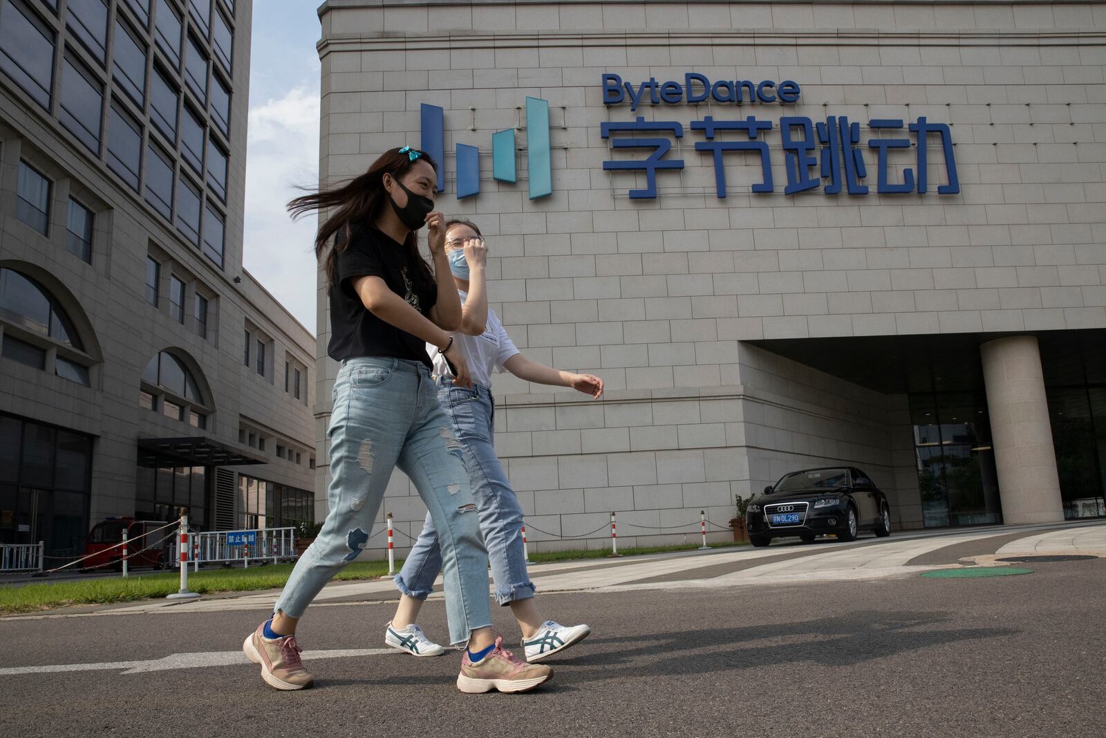 FILE - Women wearing masks to pass by the headquarters of ByteDance, owners of TikTok, in Beijing, China, Aug. 7, 2020. (AP Photo/Ng Han Guan, File)