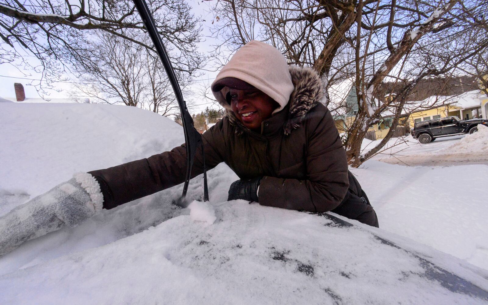 Bryana Worthy uses her hands to help break up some of the ice chunks on her vehicle on Monday, Feb. 17, 2025, in Brattleboro, Vt., after a winter storm on Sunday. (Kristopher Radder/The Brattleboro Reformer via AP)