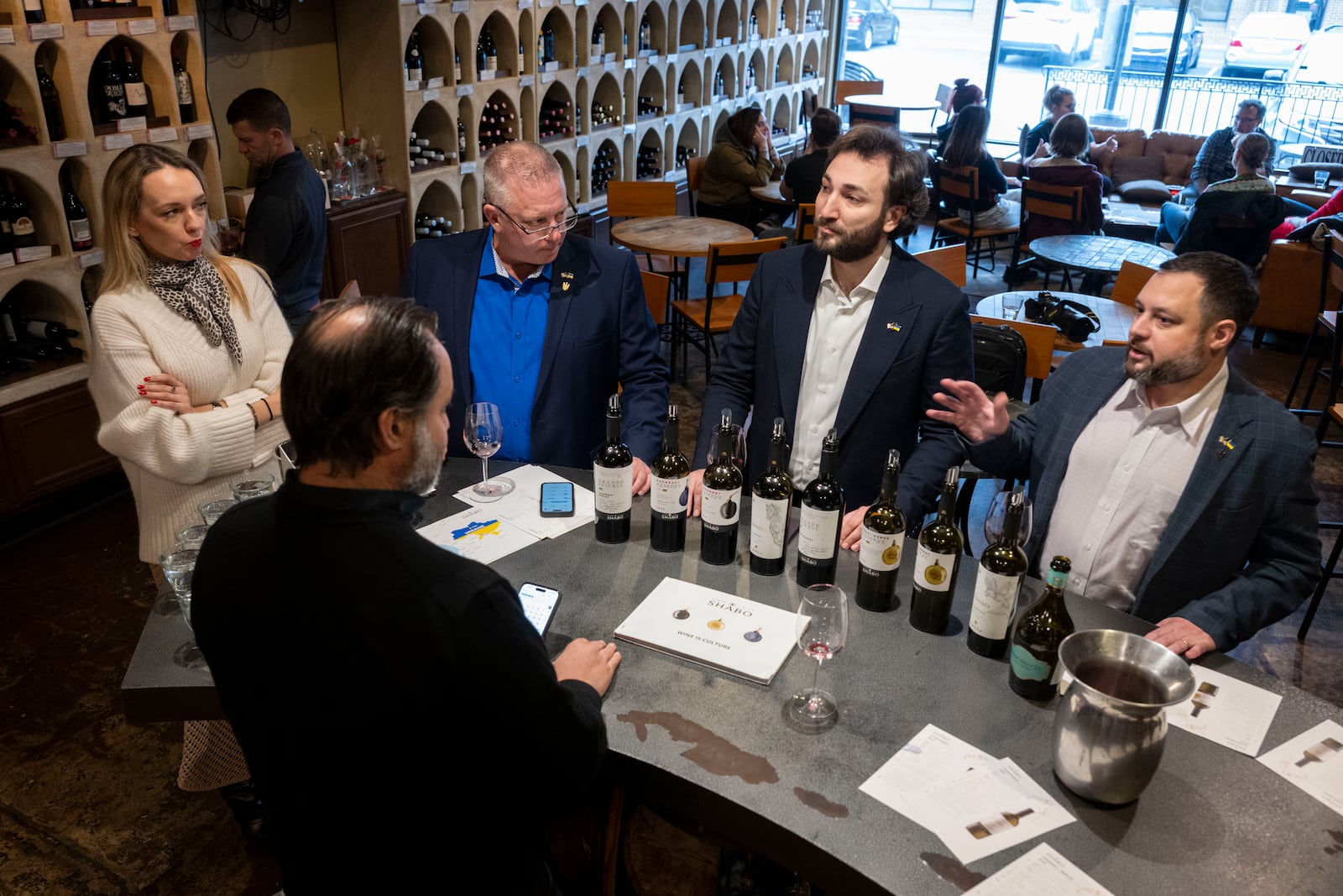 Sam Lerman, CEO of SPYRT Worldwide, right, tells why he started importing Ukrainian wine to the owner of Wine Styles Arthur Lampros, second from left, during a tasting with Giorgi Iukuridze, owner and CEO of Ukrainian winery Shabo, second from right, Joseph Belli, Sales Manager for SPYRT Worldwide, and Valentyna Parsaieva, head of export for Shabo, center left, at Wine Styles, Dec. 20, 2024 in Dumfries, Va. (AP Photo/Kevin Wolf)