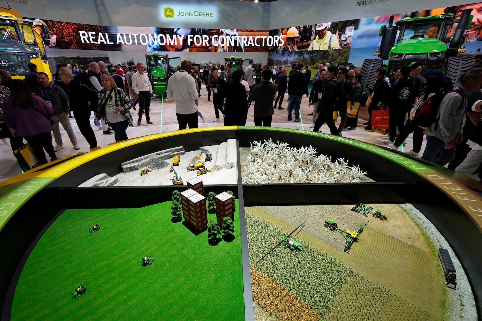 People visit the John Deere booth during the CES tech show Tuesday, Jan. 7, 2025, in Las Vegas. (AP Photo/John Locher)