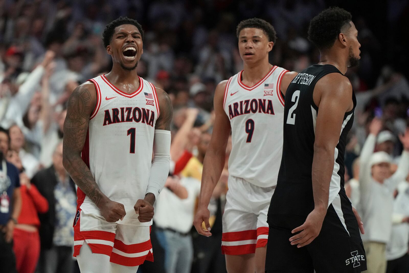 Arizona guard Caleb Love (1) and forward Carter Bryant (9) celebrate after defeating Iowa State in overtime in an NCAA college basketball game, Monday, Jan. 27, 2025, in Tucson, Ariz. (AP Photo/Rick Scuteri)