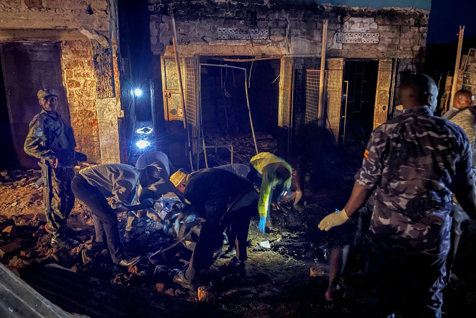 Uganda forensic officials inspect the site where a fuel truck exploded, on the outskirts of Kampala, Uganda, Tuesday, Oct. 22, 2024. (AP Photo)