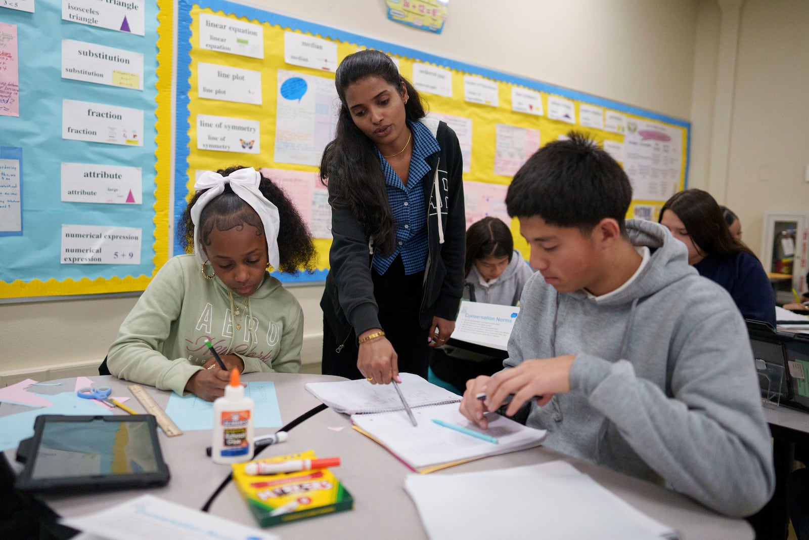 A tutor helps students at Benjamin O. Davis Middle School in Compton, Calif., Thursday, Feb. 6, 2025. (AP Photo/Eric Thayer)