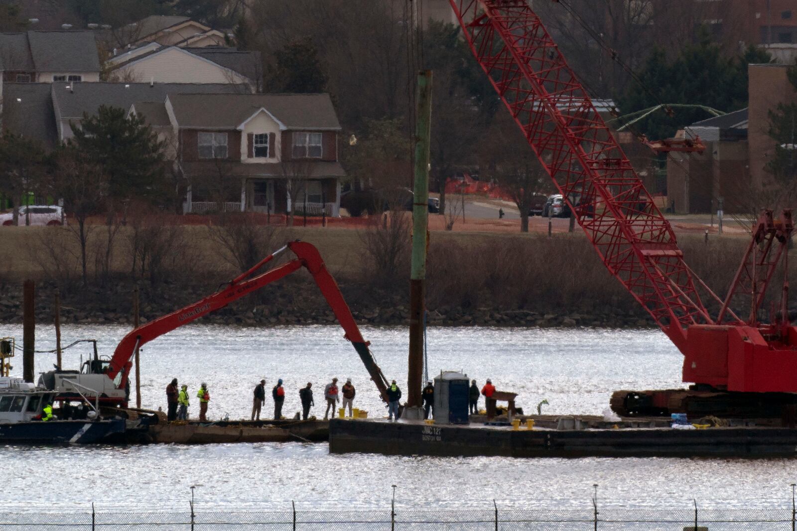 Rescue and salvage crews with cranes work to pull up the wreckage of an American Airlines jet in the Potomac River from Ronald Reagan Washington National Airport, Monday, Feb. 3, 2025, in Arlington, Va. (AP Photo/Jose Luis Magana)