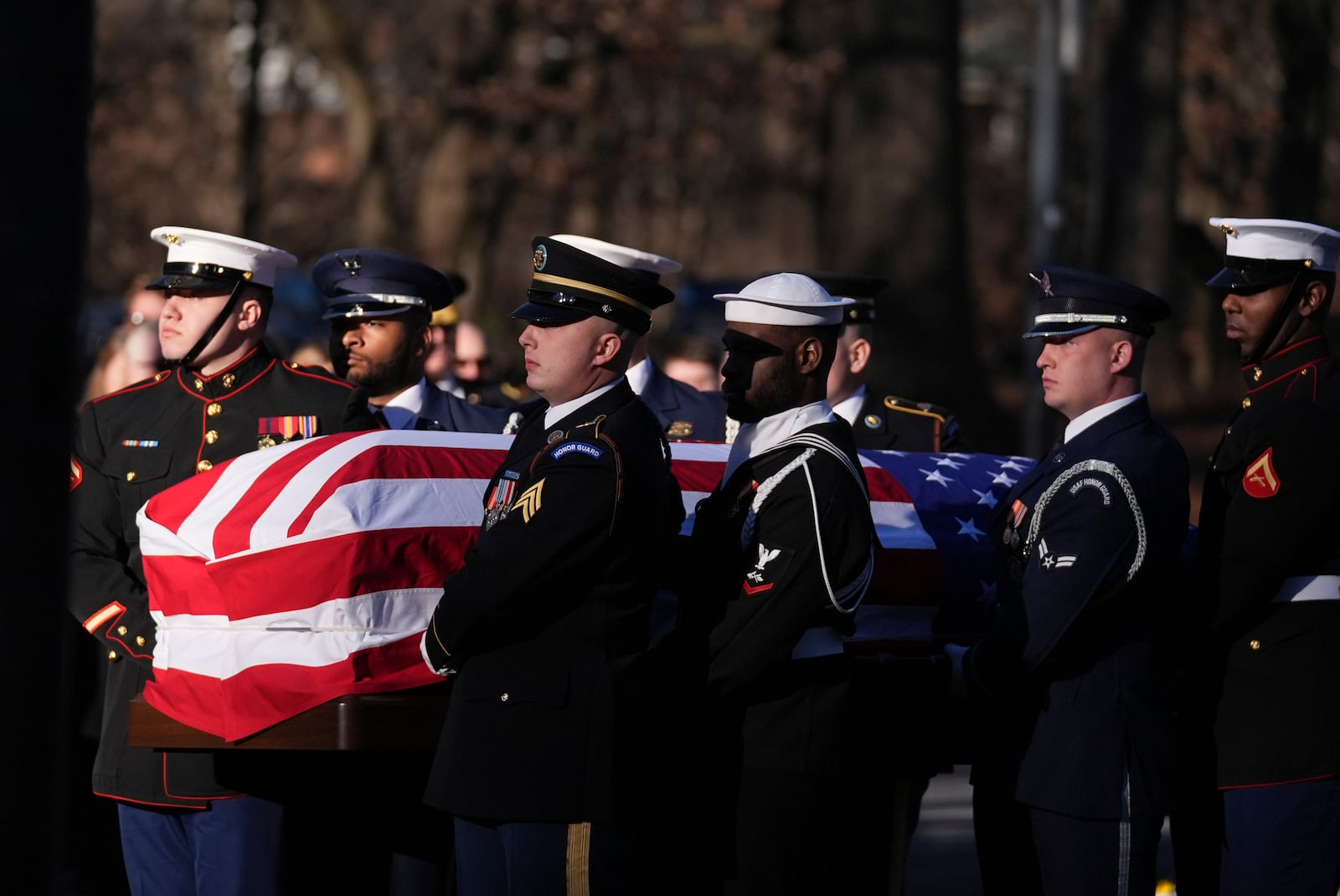 A military body bearer team carries the casket of former President Jimmy Carter into the Jimmy Carter Presidential Library and Museum to lie in repose in Atlanta, Saturday, Jan. 4, 2025. Carter died Dec. 29 at the age of 100. (AP Photo/Brynn Anderson, Pool)