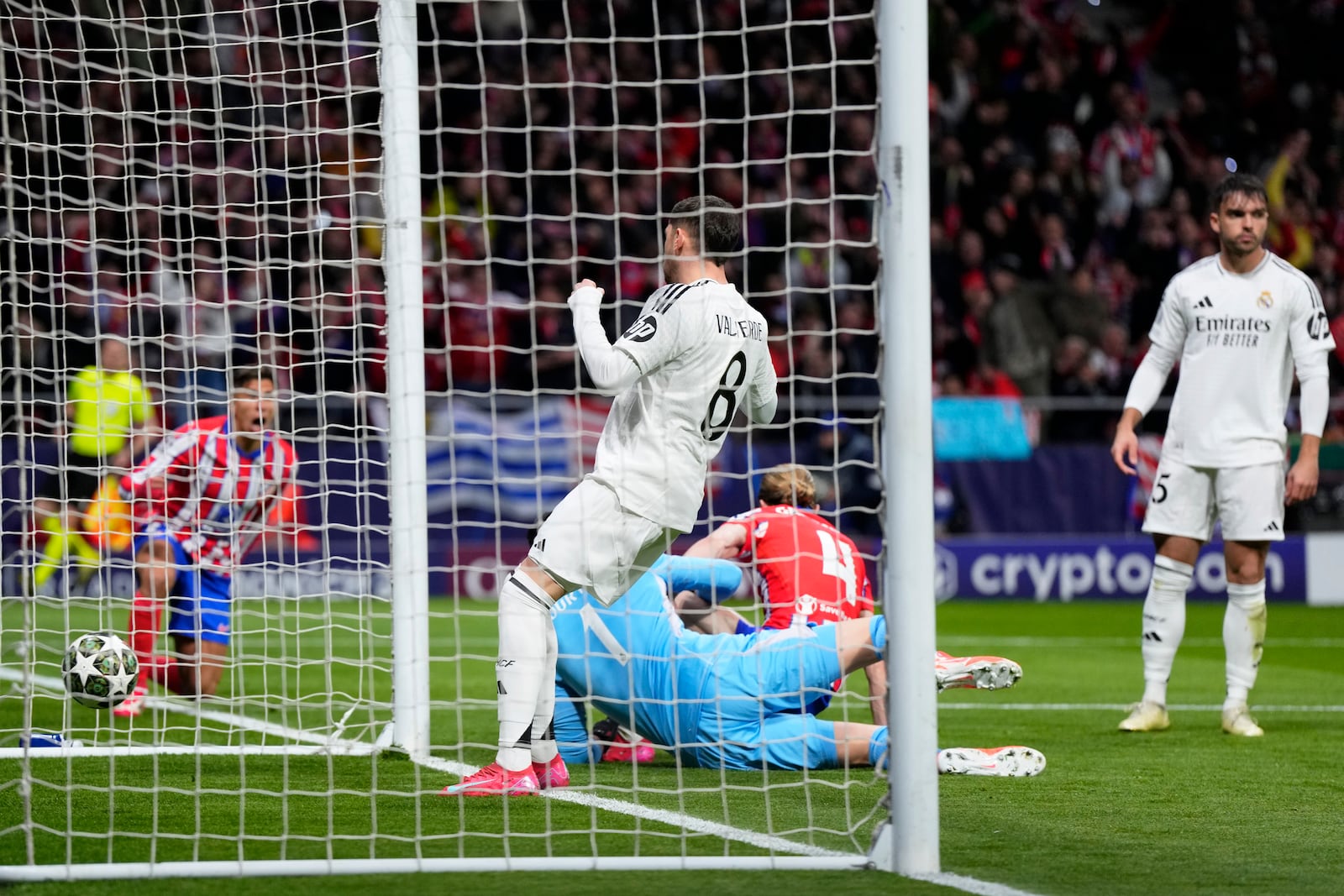 Players react after Atletico Madrid's Conor Gallagher, on the ground, scored the opening goal during the Champions League round of 16, second leg, soccer match between Atletico Madrid and Real Madrid at the Metropolitano stadium in Madrid, Spain, Wednesday, March 12, 2025. (AP Photo/Manu Fernandez)