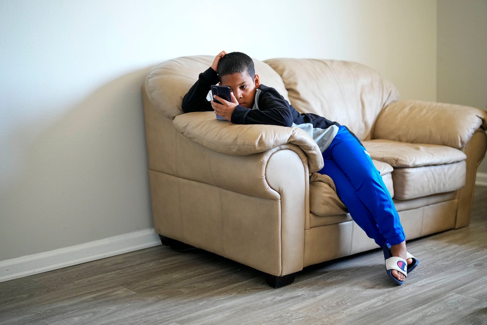 Dylan Martínez plays a game on his phone at his apartment Friday, May 18, 2024, in Aurora, Colorado. (AP Photo/Jack Dempsey)