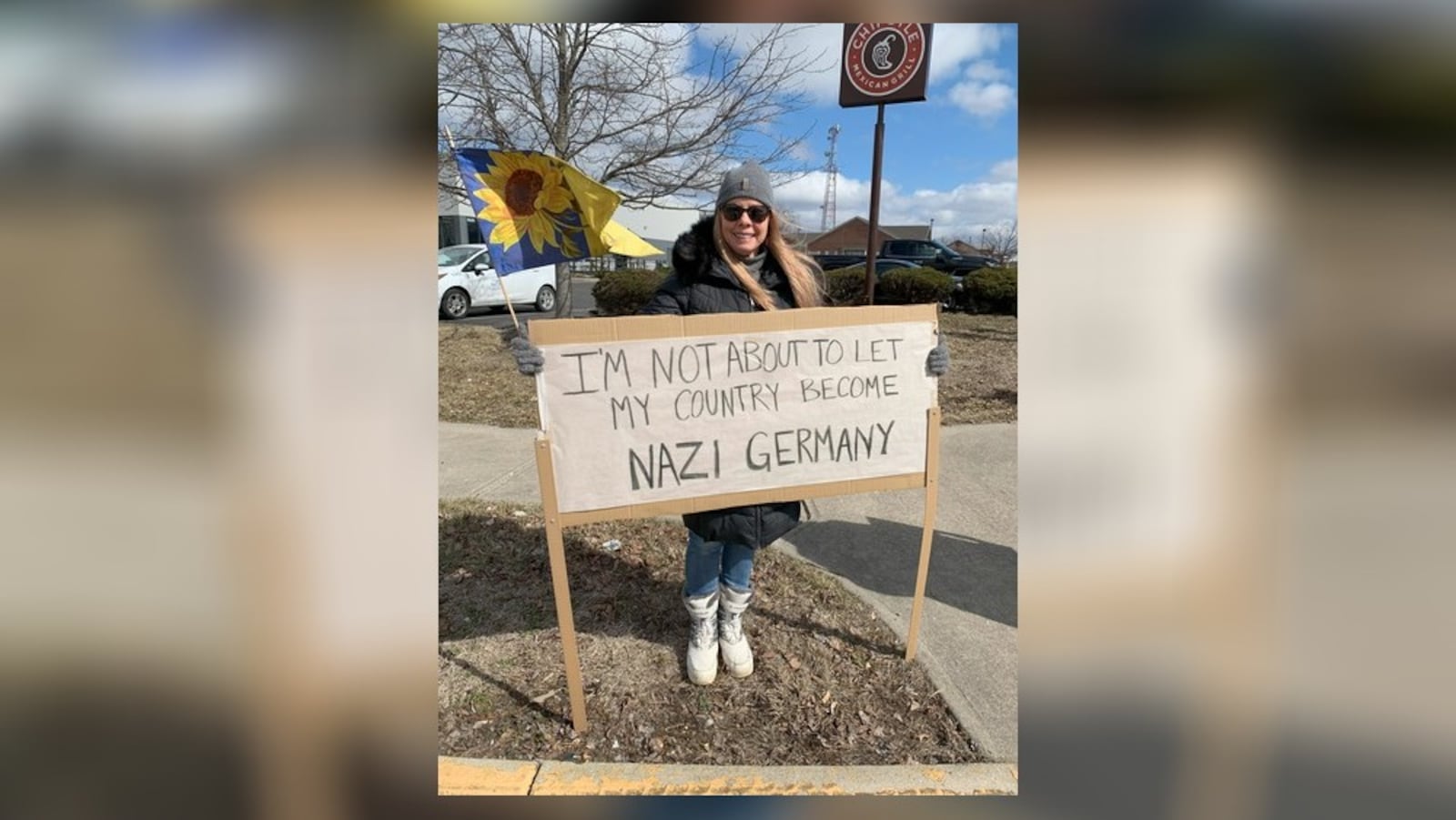 Hundreds of people lined West Dorothy Lane in Moraine on Saturday, March 1, 2025 to protest near a Tesla Service Center, including Colleen Murphy (pictured). The protest was aimed at Elon Musk, the world's richest man, and his actions with the Trump administration and the Department of Government Efficiency. BROOKE SPURLOCK/STAFF