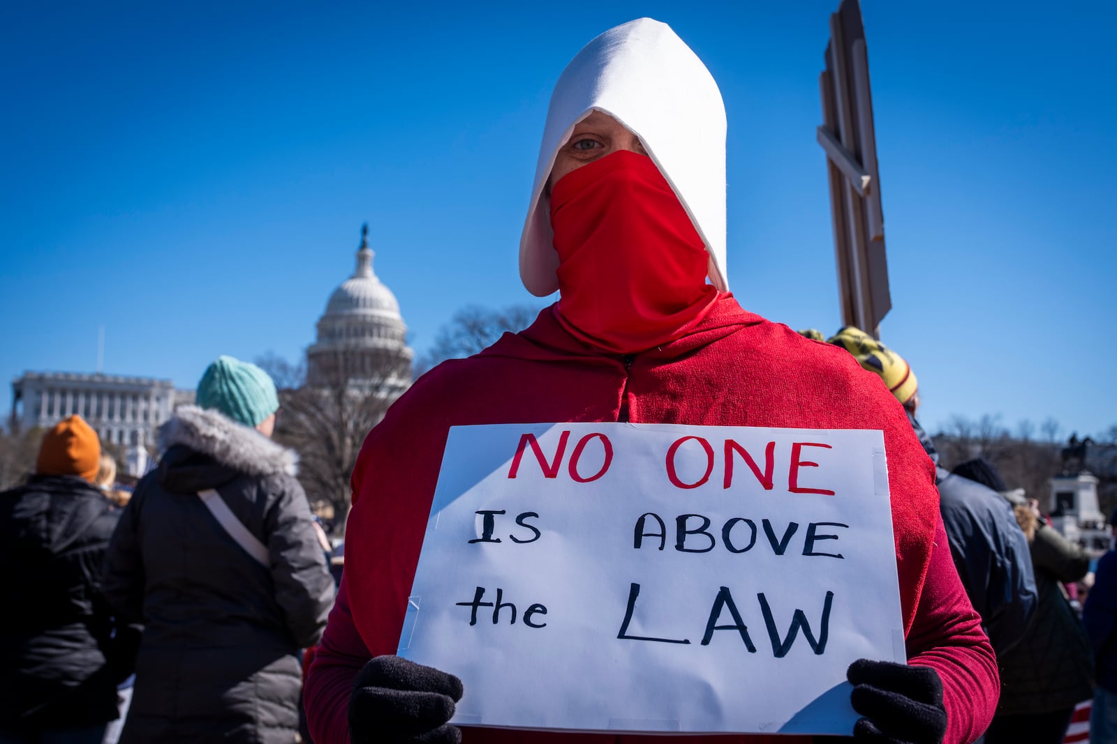 Shannon Perry, a special education teacher from Centreville, Va., wears a handmaids costume while attending a "No Kings Day" protest on Presidents Day in Washington, in support of federal workers and against recent actions by President Donald Trump and Elon Musk, Monday, Feb. 17, 2025, by the Capitol in Washington. The protest was organized by the 50501 Movement, which stands for 50 Protests 50 States 1 Movement. (AP Photo/Jacquelyn Martin)