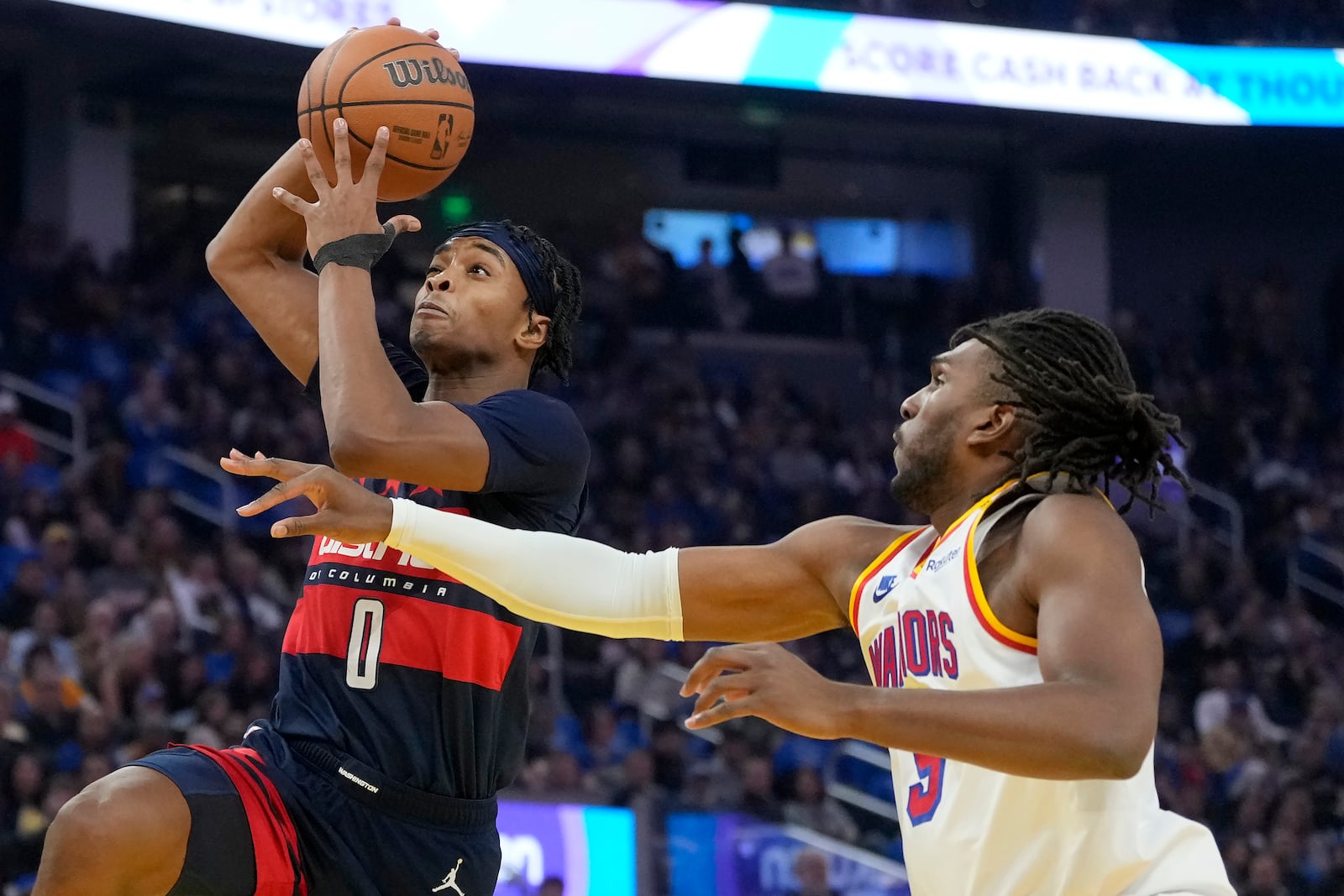 Washington Wizards guard Bilal Coulibaly (0) drives to the basket against Golden State Warriors forward Kevon Looney during the first half of an NBA basketball game in San Francisco, Saturday, Jan. 18, 2025. (AP Photo/Jeff Chiu)