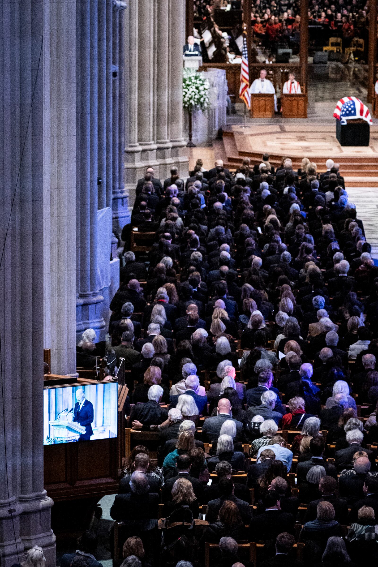 Guests listen as President Joe Biden, seen on screen, delivers remarks during the state funeral of former President Jimmy Carter at the National Cathedral, Thursday, Jan. 9, 2025, in Washington. (Haiyun Jiang/The New York Times via AP, Pool)