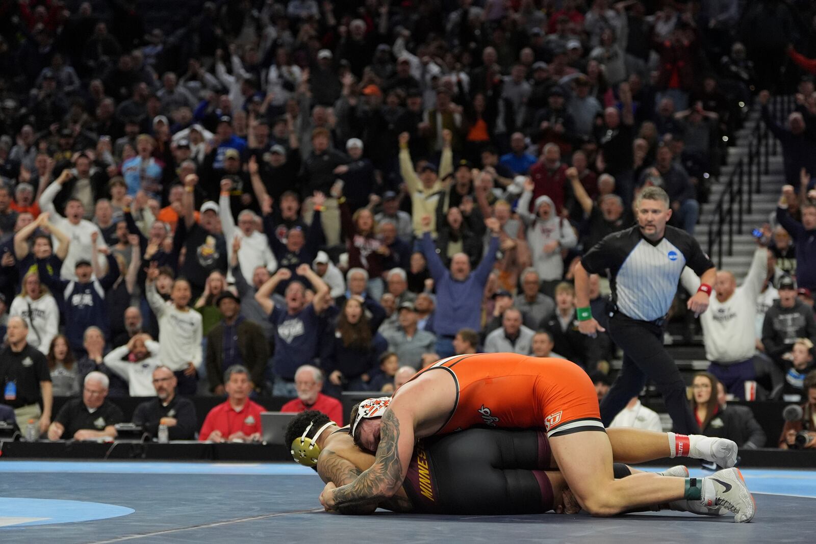 Oklahoma State's Wyatt Hendrickson, top, takes on Minnesota's Gable Steveson during a 285-pound match in the finals at the NCAA wrestling championship, Saturday, March 22, 2025, in Philadelphia. (AP Photo/Matt Rourke)