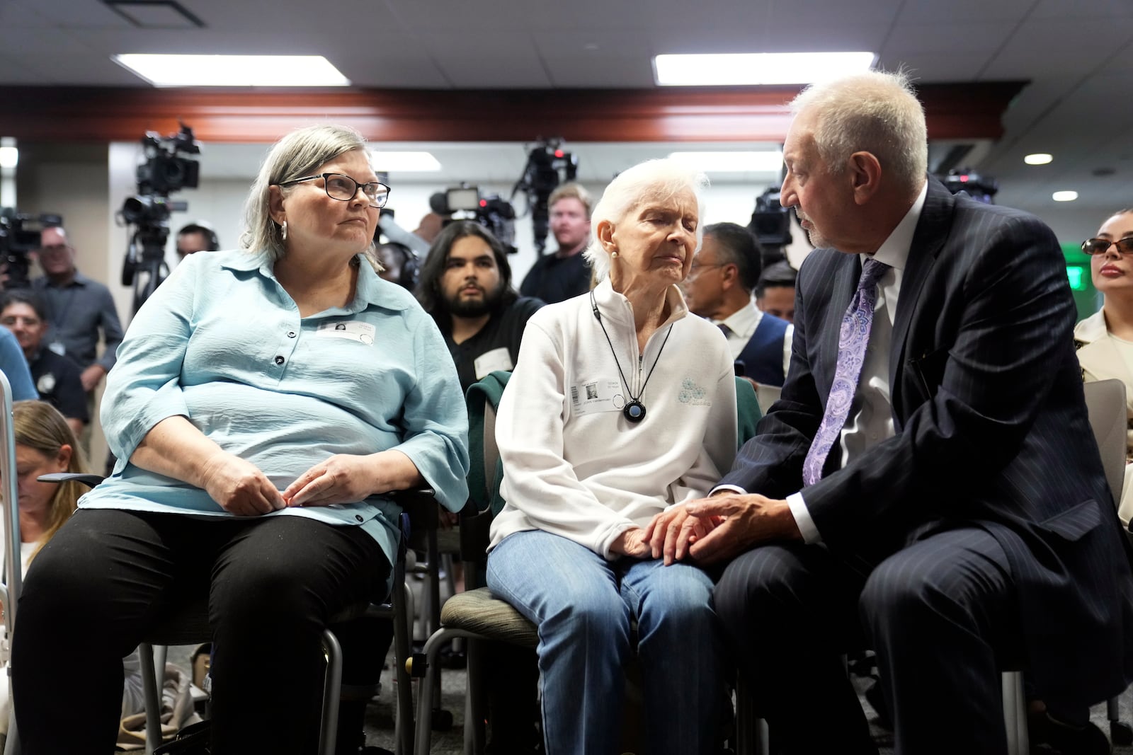 Kitty Menendez's sister, Joan Andersen VanderMolen, center is greeted by Defense Attorney Mark Geragos as Diane Hernandez niece of Kitty Menendez, left, looks on prior to a news conference being held by Los Angeles County District Attorney George Gascon at the Hall of Justice on Thursday, Oct. 24, 2024, in Los Angeles. (AP Photo/Eric Thayer)