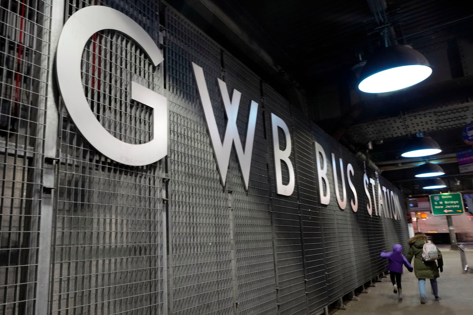 Pedestrian walk outside George Washington Bridge Bus Station in New York, Friday, Dec. 6, 2024, where the gunman fleeing Wednesday's shooting of UnitedHealthcare CEO Brian Thompson took a taxi to, according to surveillance video. (AP Photo/Richard Drew)