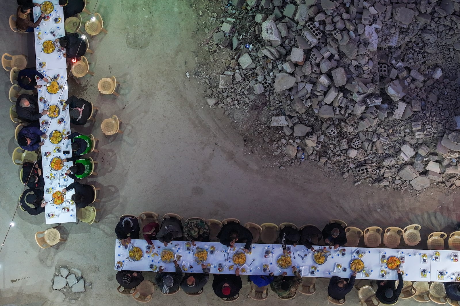 Residents gather for iftar, the fast-breaking meal, organized by the Turkish Humanitarian Relief Foundation (IHH), on the first day of Ramadan in the Jobar neighborhood, which was devastated by the Syrian war, in Damascus, Syria, on Saturday, March 1, 2025.(AP Photo/Ghaith Alsayed)