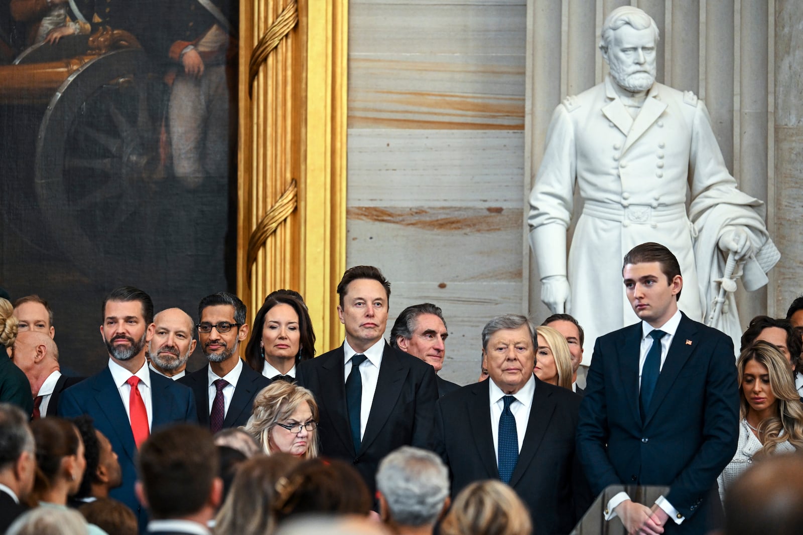 Donald Trump Jr., from left, Howard Lutnick, Sundar Pichai, Elon Musk, Viktor Knavs and and Barron Trump arrive at the 60th Presidential Inauguration in the Rotunda of the U.S. Capitol in Washington, Monday, Jan. 20, 2025. (Kenny Holston/The New York Times via AP, Pool)