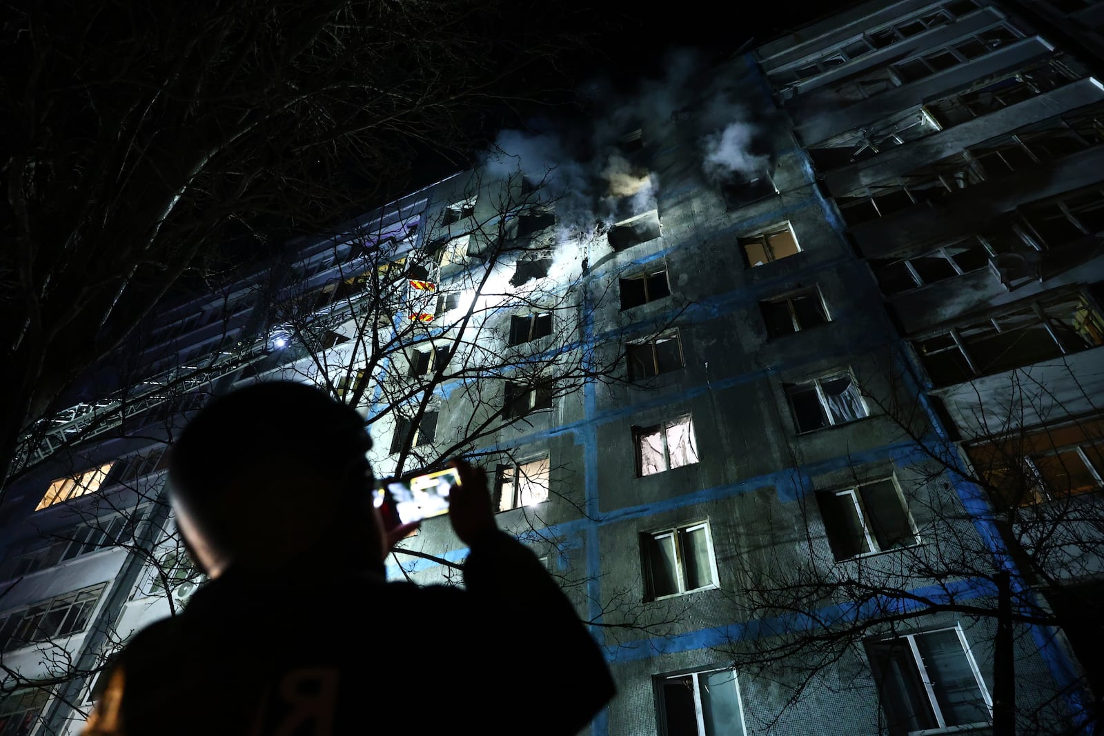 A rescue worker takes photo of a multi-storey building damaged by a Russian drone strike on a residential neighbourhood in Zaporizhzhia, Ukraine, Friday, Feb. 28, 2025. (AP Photo/Kateryna Klochko)