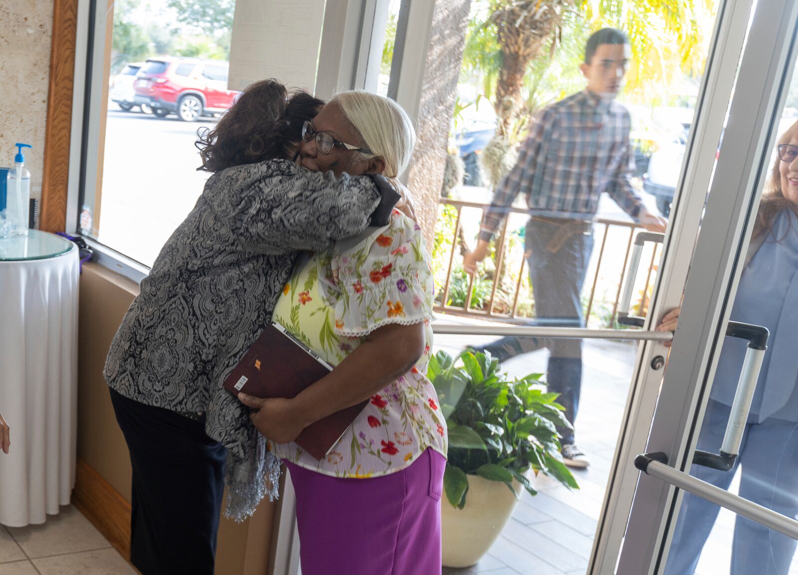 Church usher Vanessa Almanzar, left, embraces a parishioner as she arrives for a worship service at the Centro Cristiano El Pan de Vida, a mid-size Church of God of Prophecy congregation in Kissimmee, Florida, Sunday, Feb. 2, 2025. (AP Photo/ Alan Youngblood)