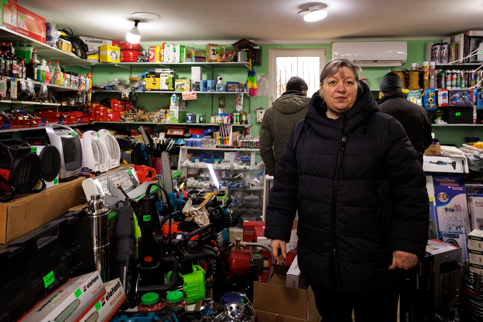 Carina Cazac, a shop owner, stands next to electrical heaters in Copanca, Moldova, Wednesday, Jan. 8, 2025. (AP Photo)