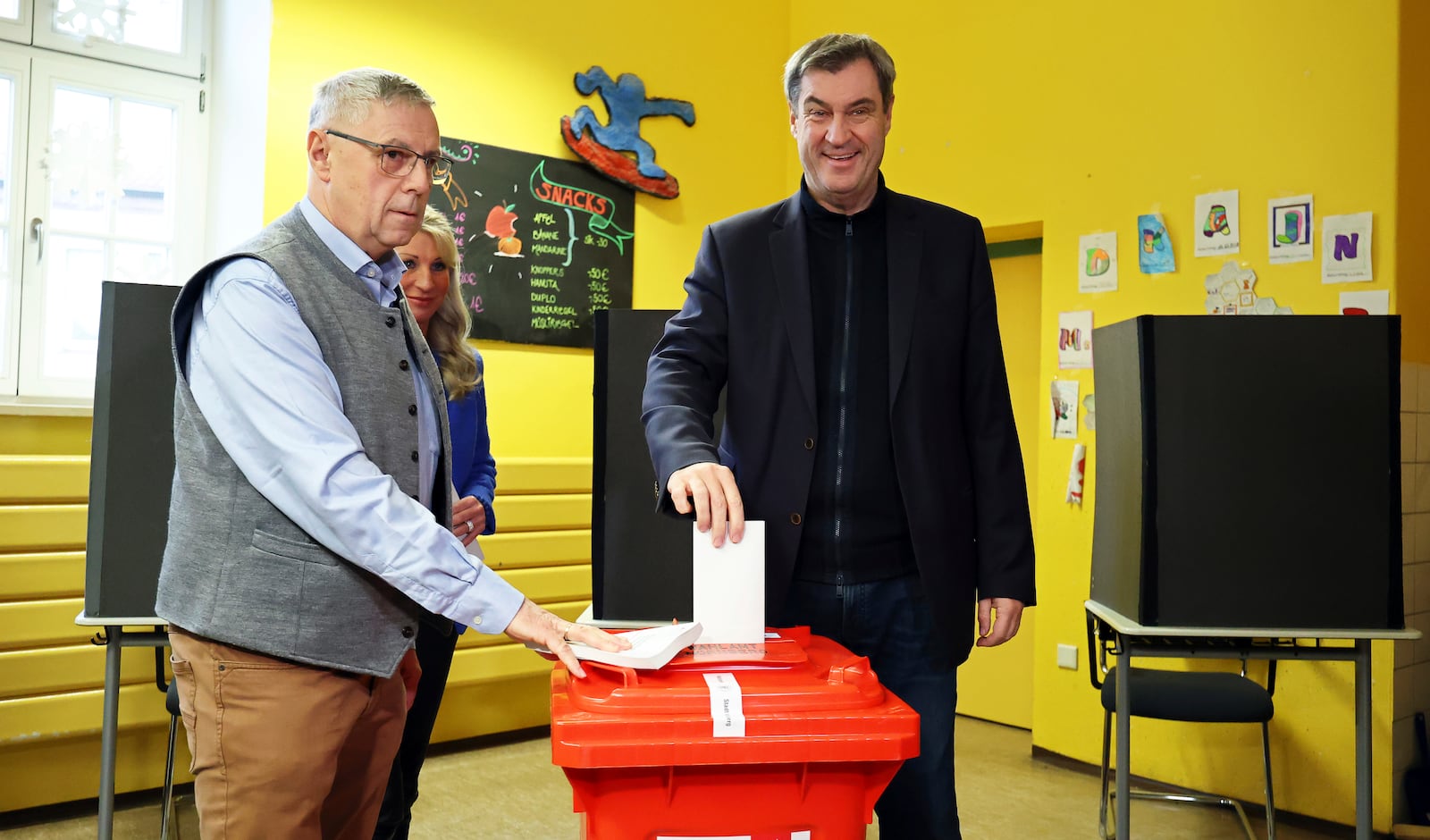 The governor of the German state of Bavaria and leader of the Christian Social Union (CSU), Markus Soeder, right, casts his vote at a polling station in Nuremberg, Germany, Sunday, Feb. 23, 2025, during the national election. (Daniel Karmann/dpa via AP)