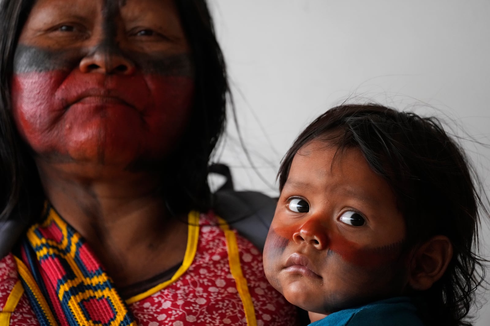 An Indigenous woman holds her son during a protest against the prospective creation of a benchmark time limit that threatens to strip some Indigenous lands, in Brasilia, Brazil, Wednesday, Oct. 30, 2024. (AP Photo/Eraldo Peres)