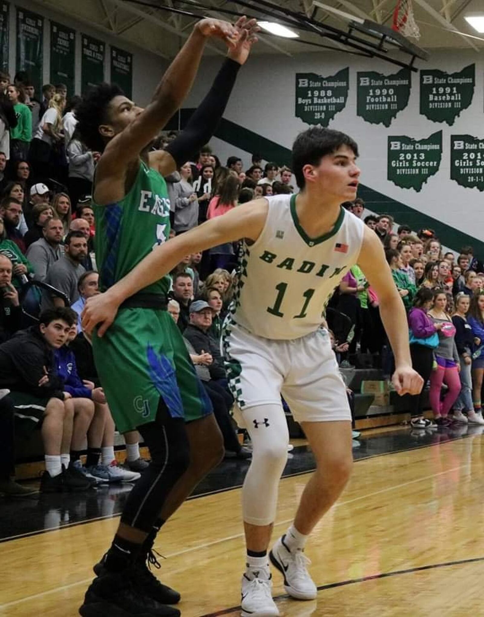 Badin’s Spencer Giesting (11) and Chaminade Julienne’s Dominic Wilcox (5) watch a shot by Wilcox during Friday night’s game at Mulcahey Gym in Hamilton. CJ won 58-54. CONTRIBUTED PHOTO BY TERRI ADAMS