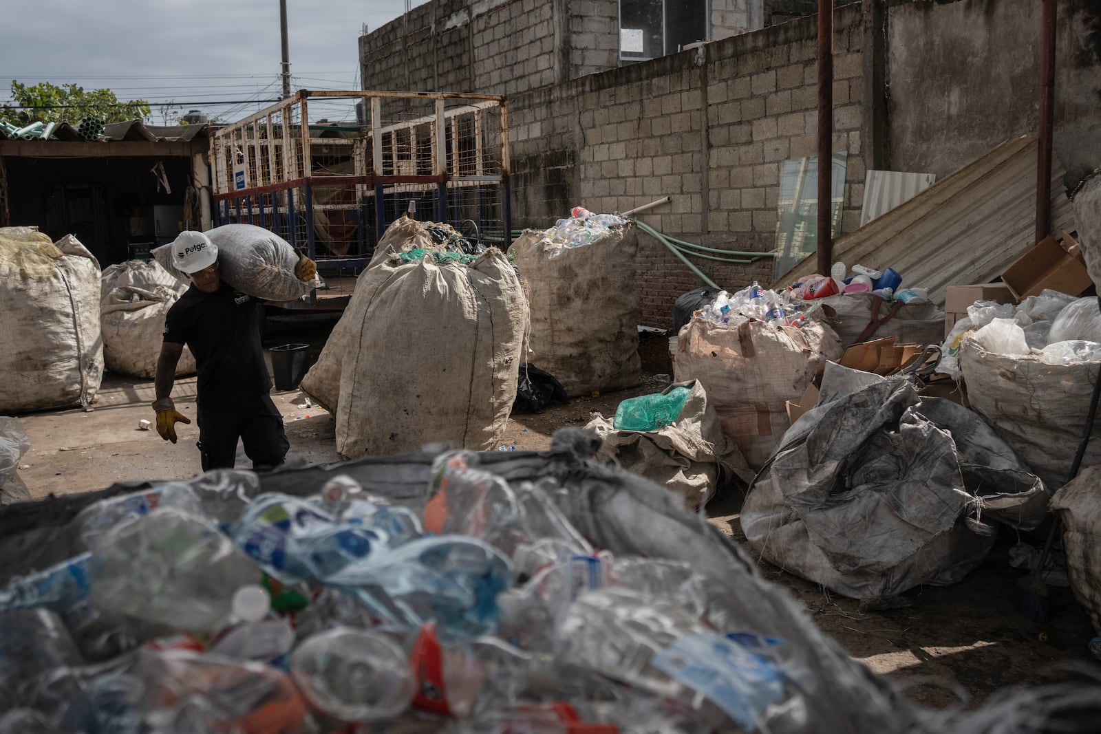 Jesus Cuevas, a Petgas technician, carries a bag filled with shredded plastic, at a recycling center in Boca del Rio, Veracruz, Mexico, Jan. 4, 2025. (AP Photo/Felix Marquez)