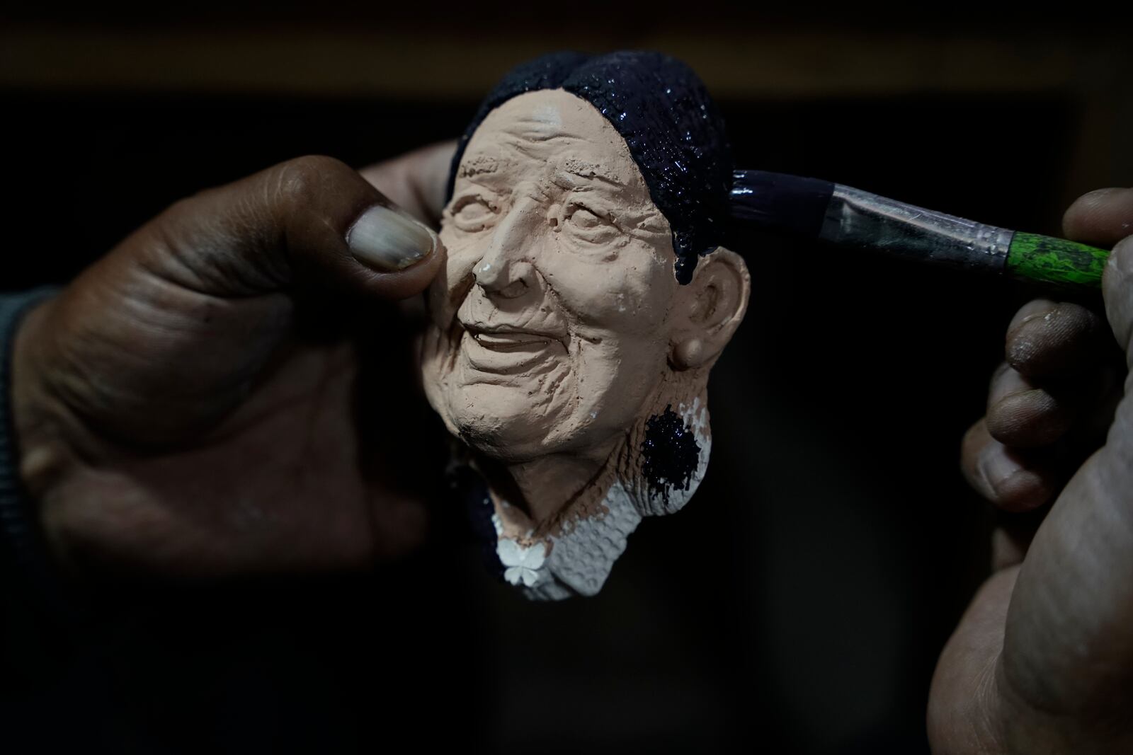 Artisan William Luna creates a mask of a real person to adorn tantawawa, a sweet bread traditional for Day of the Dead celebrations, in La Paz, Bolivia, Thursday, Oct. 31, 2024. (AP Photo/Freddy Barragan)