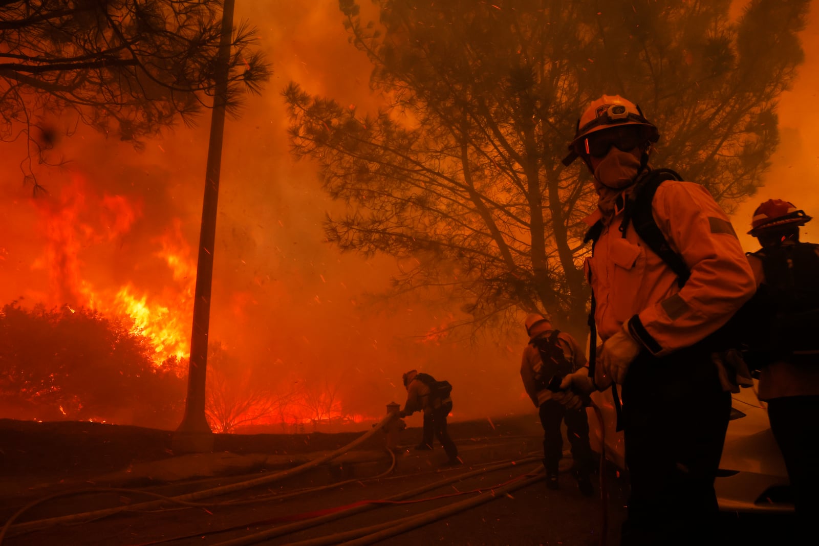 Firefighters battle the advancing Palisades Fire in the Pacific Palisades neighborhood of Los Angeles, Tuesday, Jan. 7, 2025. (AP Photo/Etienne Laurent)