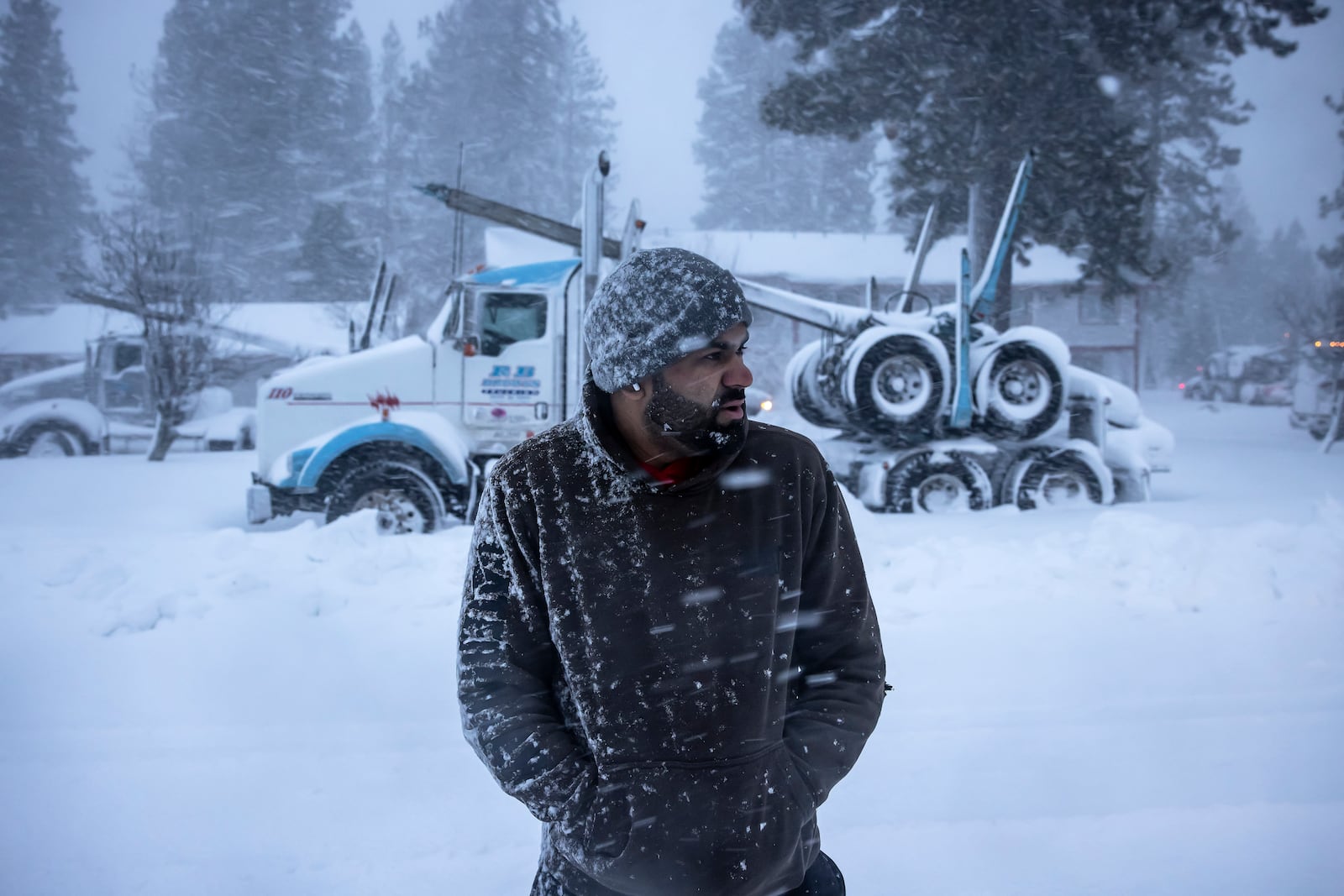 Truck driver Harry Singh of Seattle looks down Shastina Drive where several dozen big rigs were gathered after being stuck overnight in Weed, Calif., Wednesday, Nov. 20, 2024. (Carlos Avila Gonzalez/San Francisco Chronicle via AP)