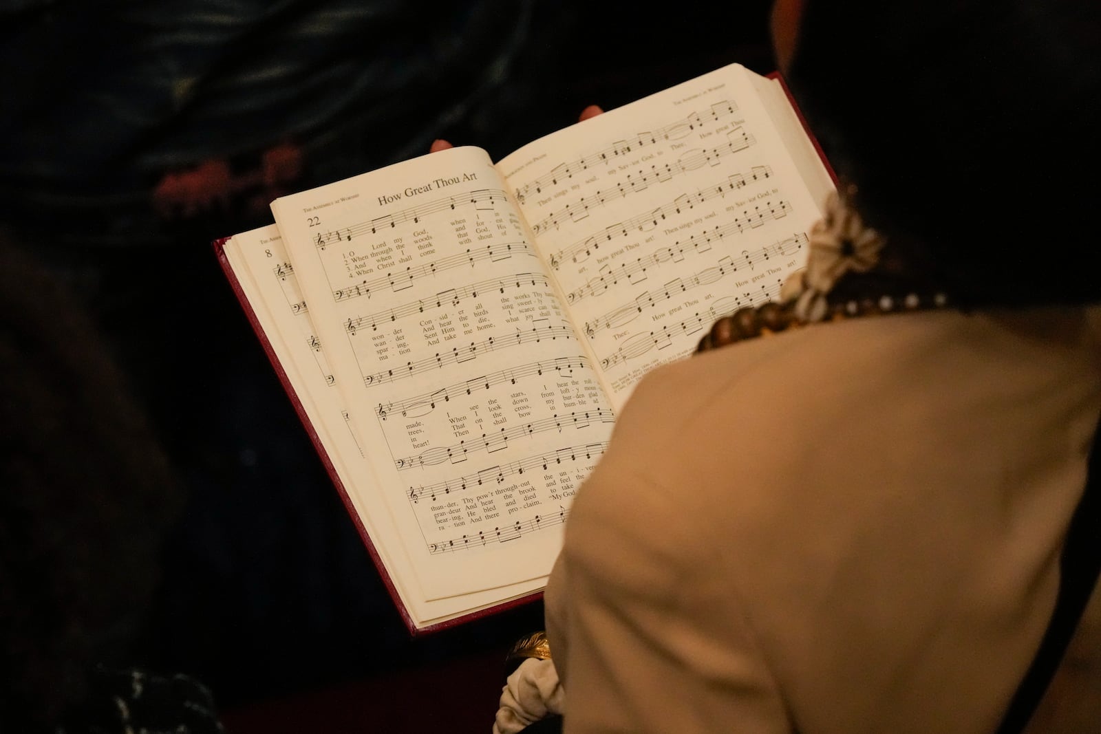 A person follows along as the hymn "How Great Thou Art" is sung during a ceremony in celebration of Roberta Flack's life at The Abyssinian Baptist Church on Monday, March 10, 2025, in New York. (AP Photo/Richard Drew)