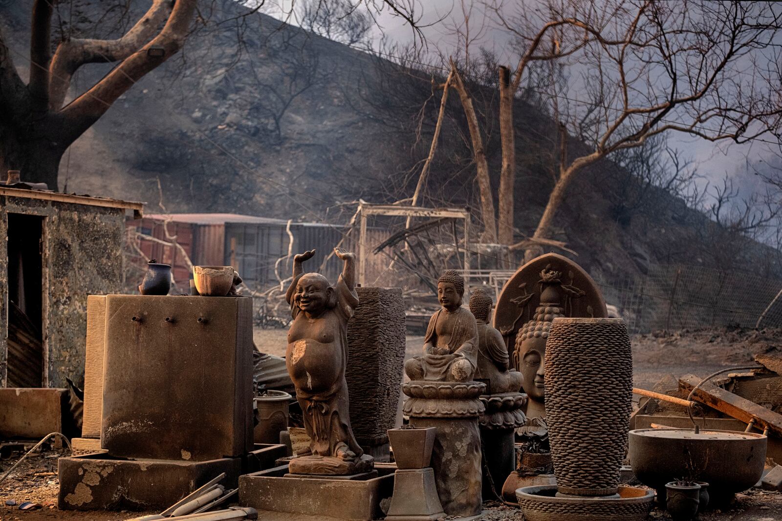 Charred Buddha statues stand amidst other sculptures at burned out shop in Malibu, Calif., Wednesday, Jan. 8, 2025. (AP Photo/Richard Vogel)