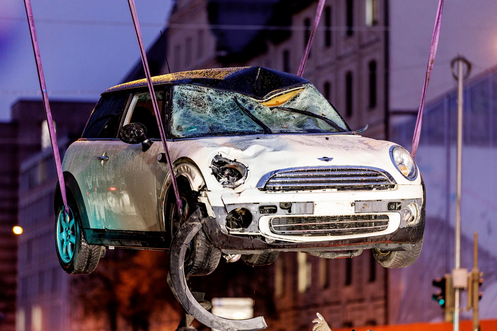 A car is lifted onto a tow truck at the scene where a driver drove a car into a labor union demonstration in Munich, Germany, Thursday Feb. 13, 2025. (Matthias Balk/dpa via AP)