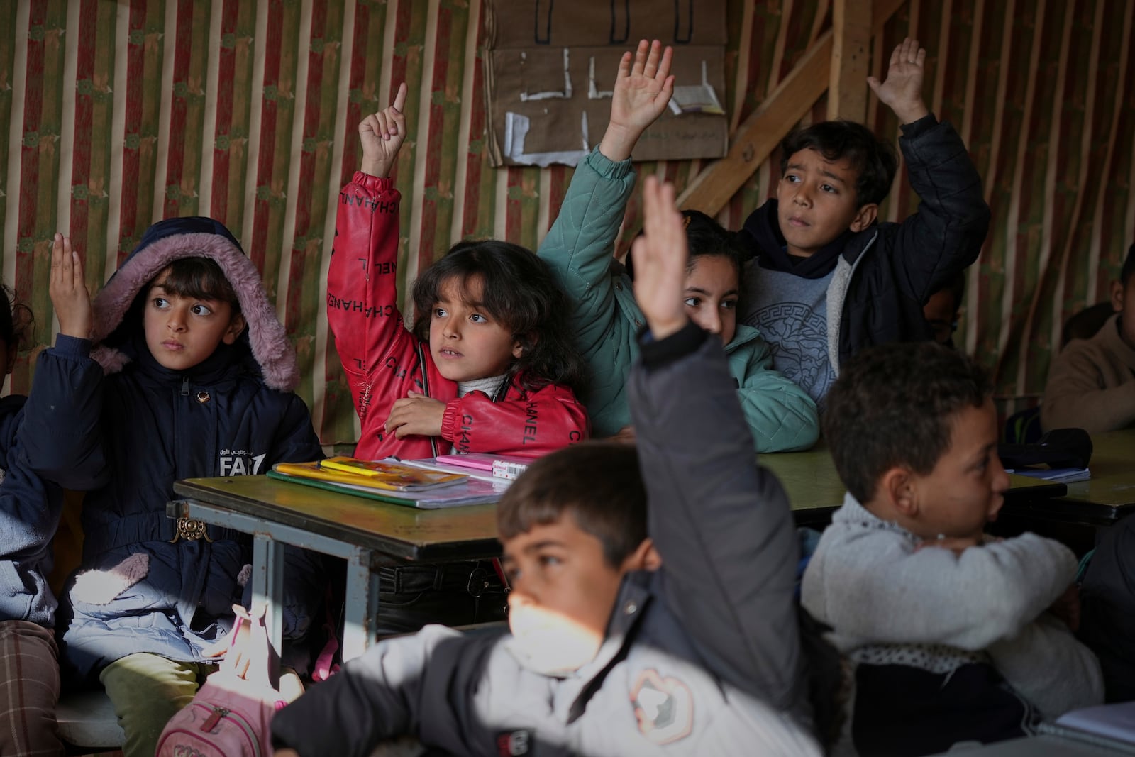 Palestinian children take a lesson in a makeshift classroom located within a school compound, which is also serving as a shelter for displaced people in Gaza City, Monday March 10, 2025. (AP Photo/(AP Photo/Jehad Alshrafi)