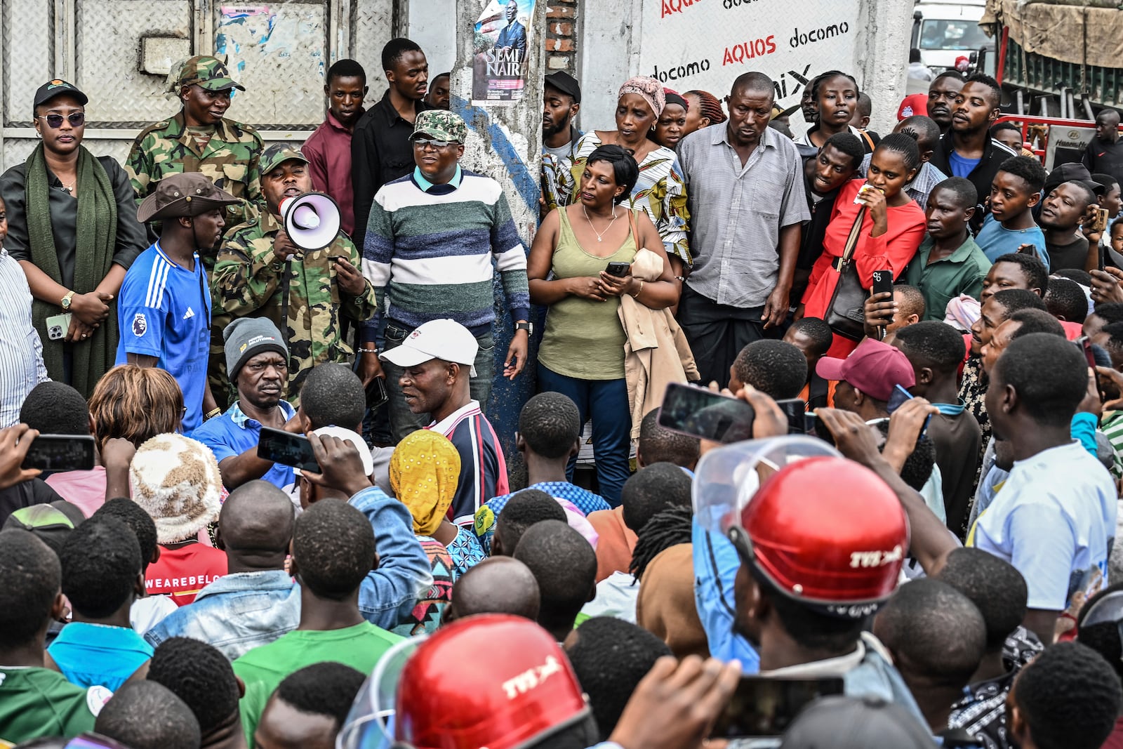 Residents listen to M23 rebel soldiers in Goma, Democratic republic of the Congo, Friday, Jan. 31, 2025. (AP Photo/Moses Sawasawa)