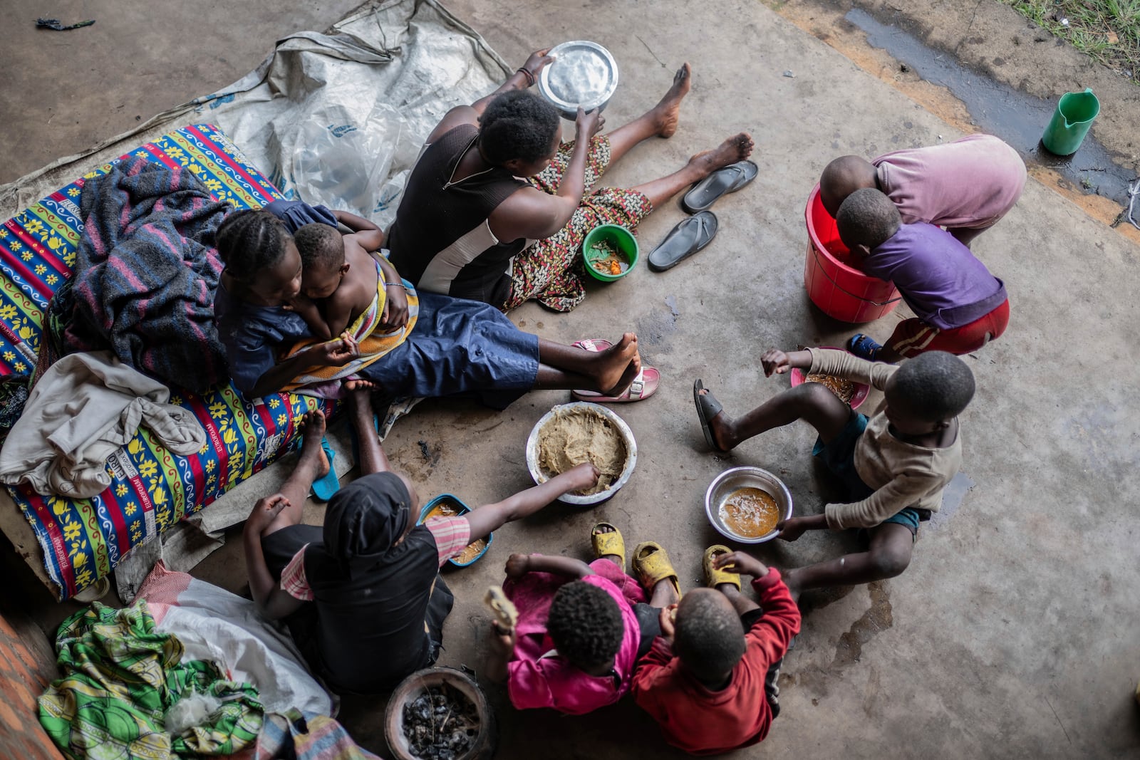 Zawadi Sifa who has been fleeing fighting from camp to camp, shares food with her seven children in Goma, Democratic Republic of the Congo, Thursday, Feb. 5, 2025.(AP Photo/Moses Sawasawa)