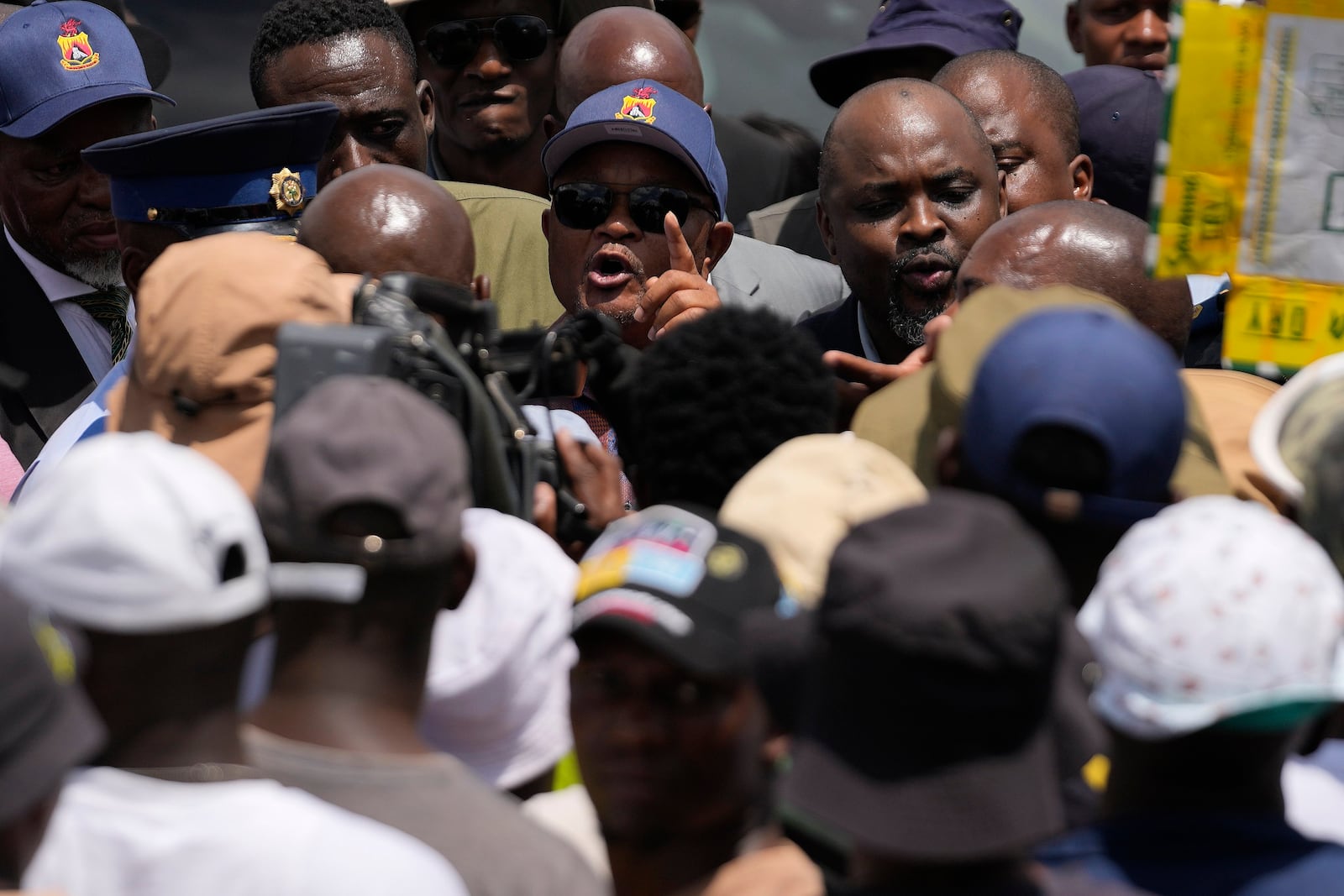 South Africa's Police minister Senzo Mchunu, centre, attempts talking to family members and activists after visiting an abandoned gold mine, where miners are rescued from below ground, in Stilfontein, South Africa, Tuesday, Jan. 14, 2025. (AP Photo/Themba Hadebe)