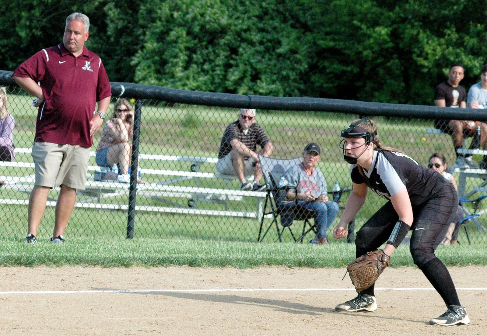 Lakota East third baseman Cassidy Hudson takes a defensive position as Lebanon’s Brian Kindell stands in the third-base coaching box Friday during a Division I district softball final at Centerville. East won 3-0. RICK CASSANO/STAFF